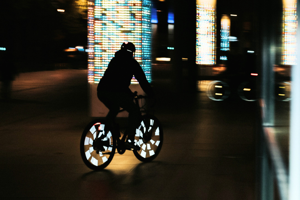 Cycliste de nuit, roues éclairées par des réflecteurs Rainette